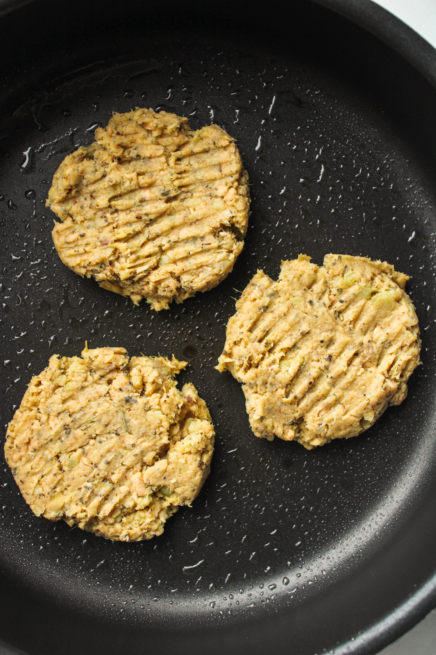 sweet potato salmon patties on a black frying pan