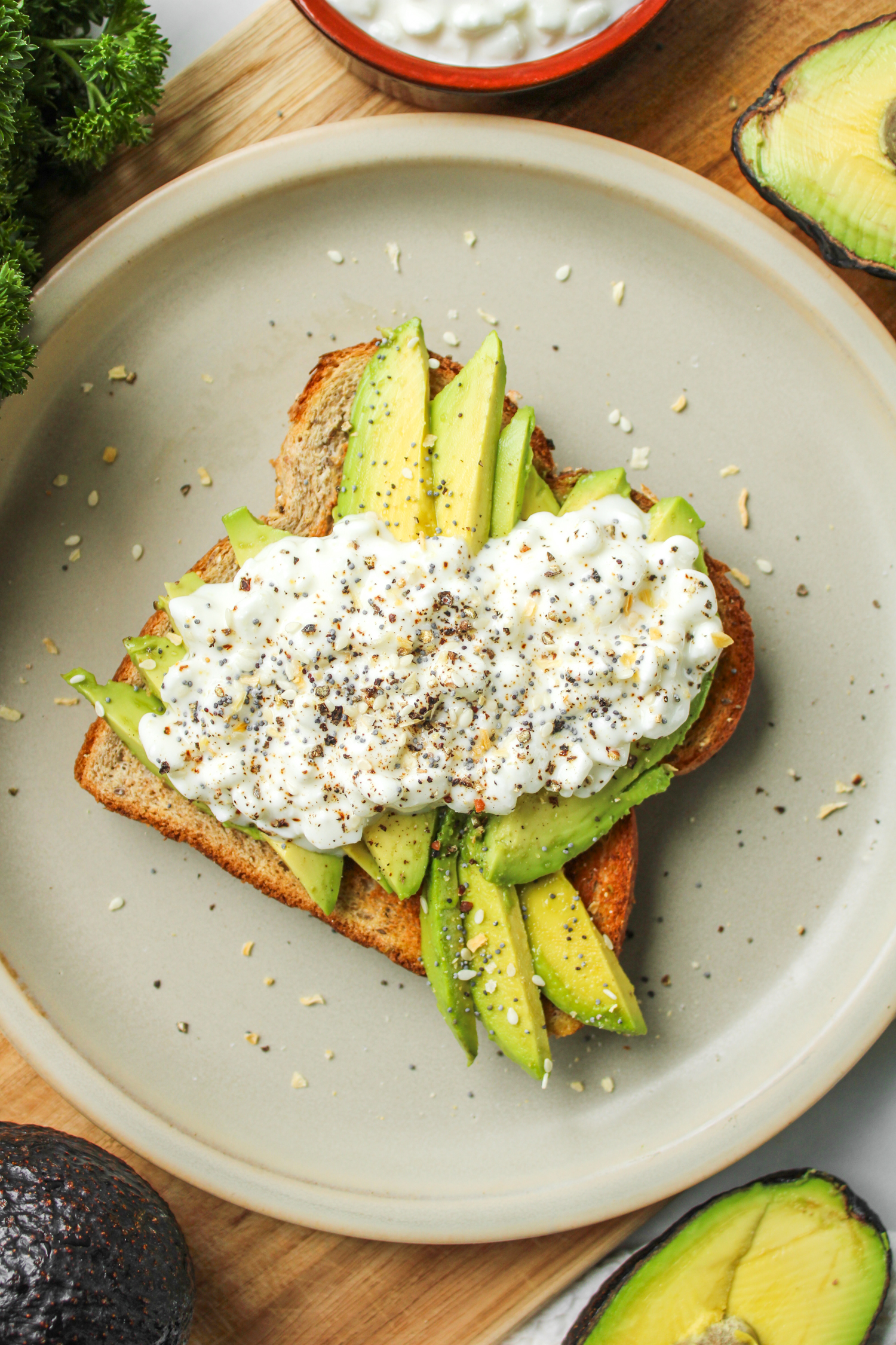 avocado toast with cottage cheese on top of grey ceramic plate