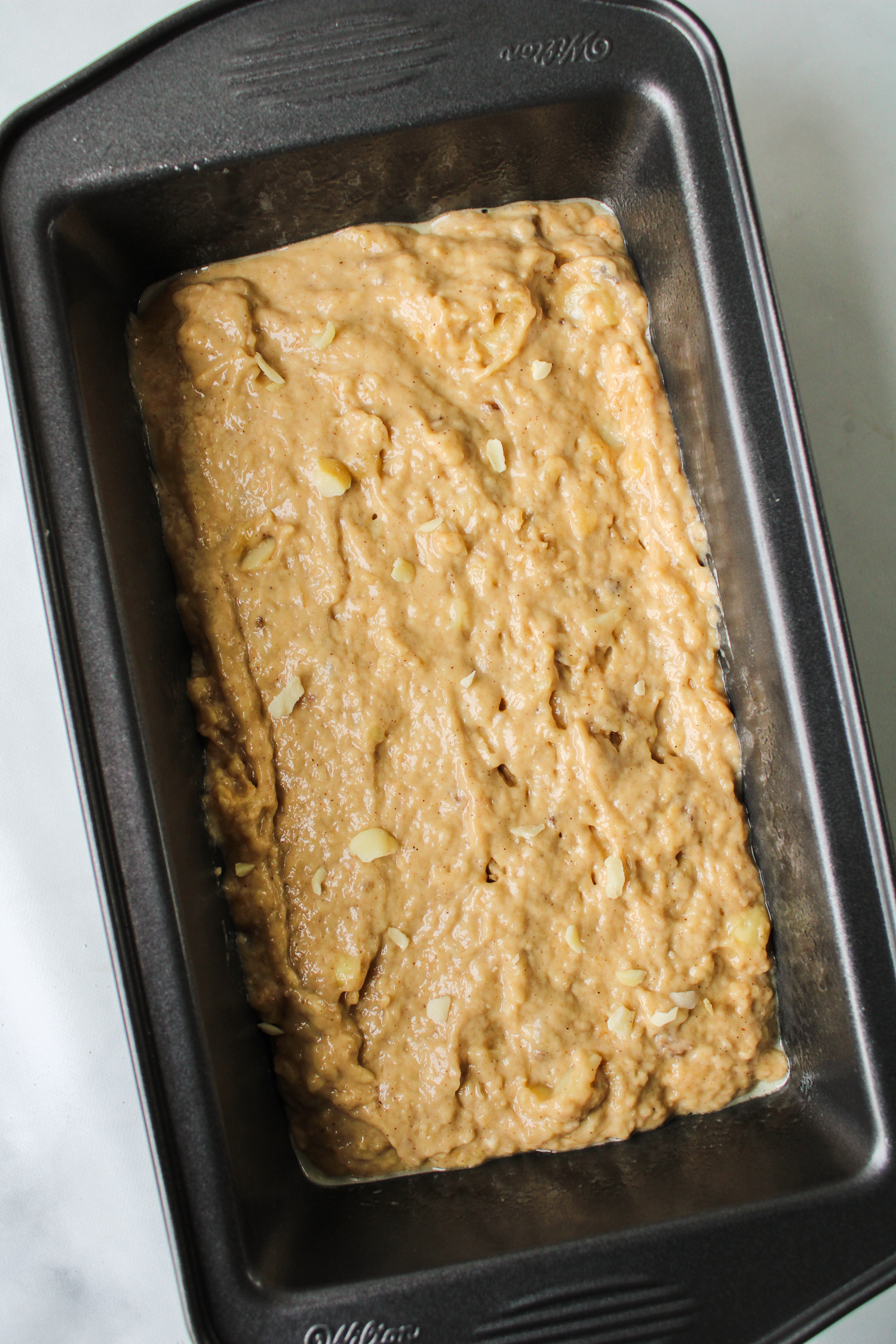 raw macadamia banana loaf batter in a black loaf pan