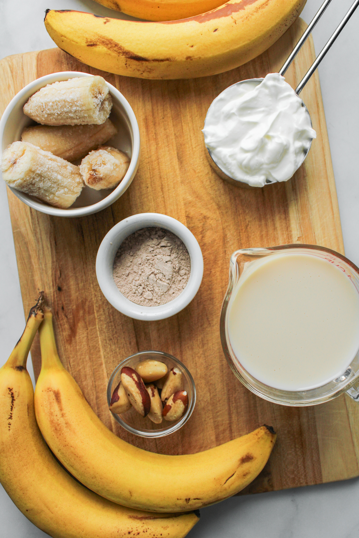 chocolate banana smoothie ingredients laid out on top of a wooden board