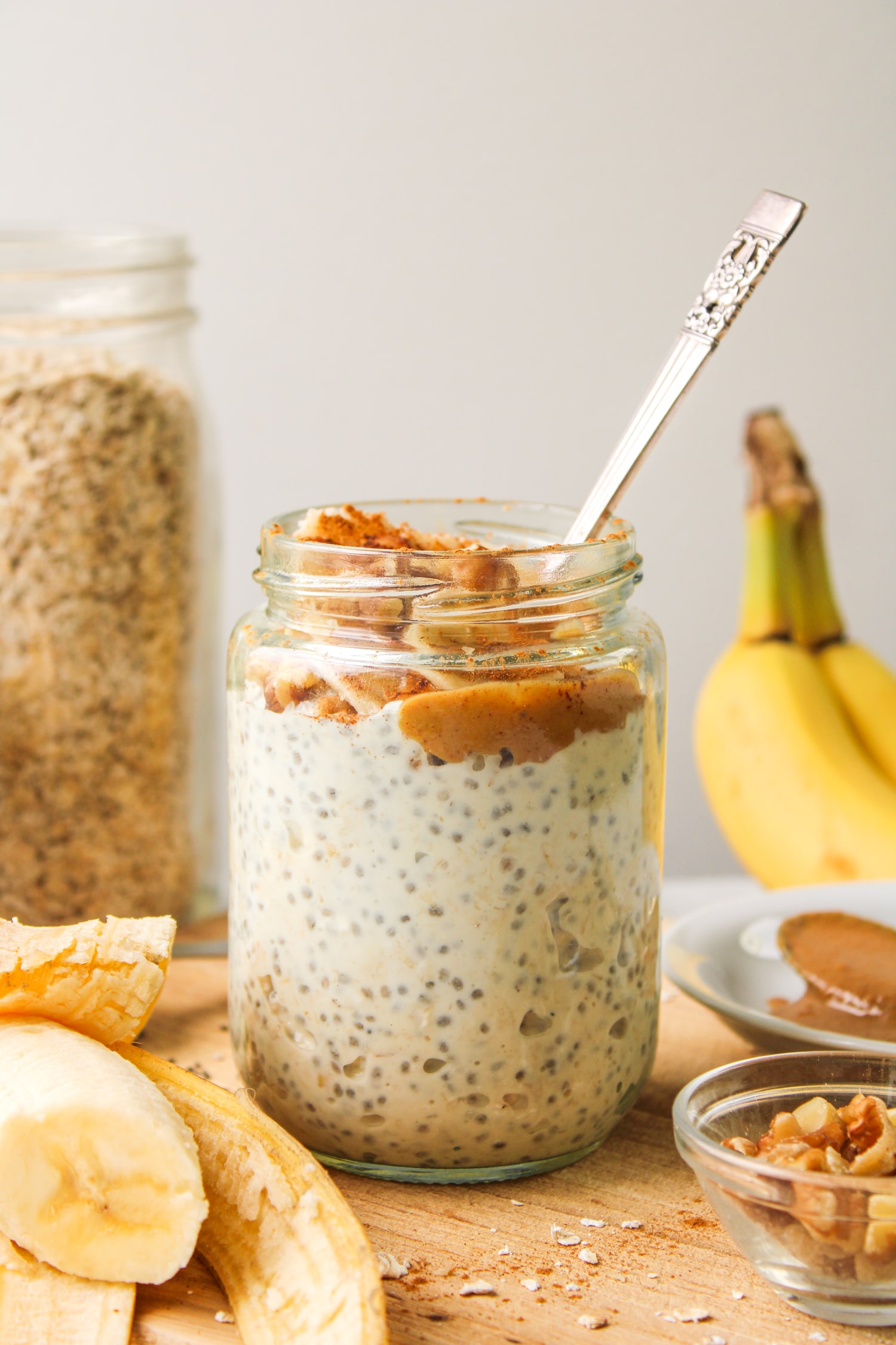 banana chia overnight oats in a glass jar, topped with peanut butter, banana and cinnamon