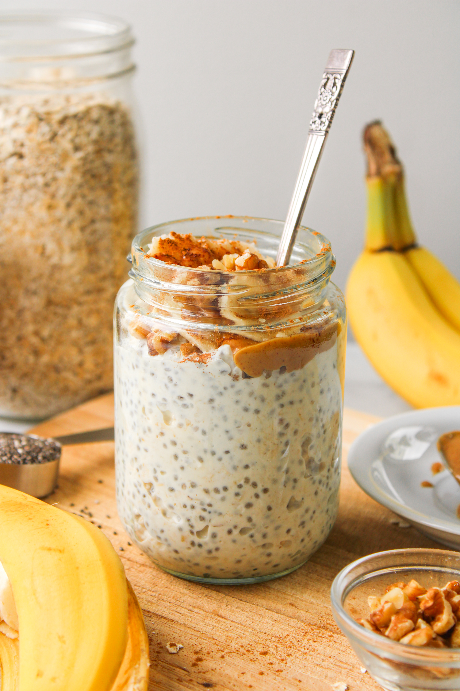 banana peanut butter overnight oats in a glass jar, topped with peanut butter, banana and cinnamon