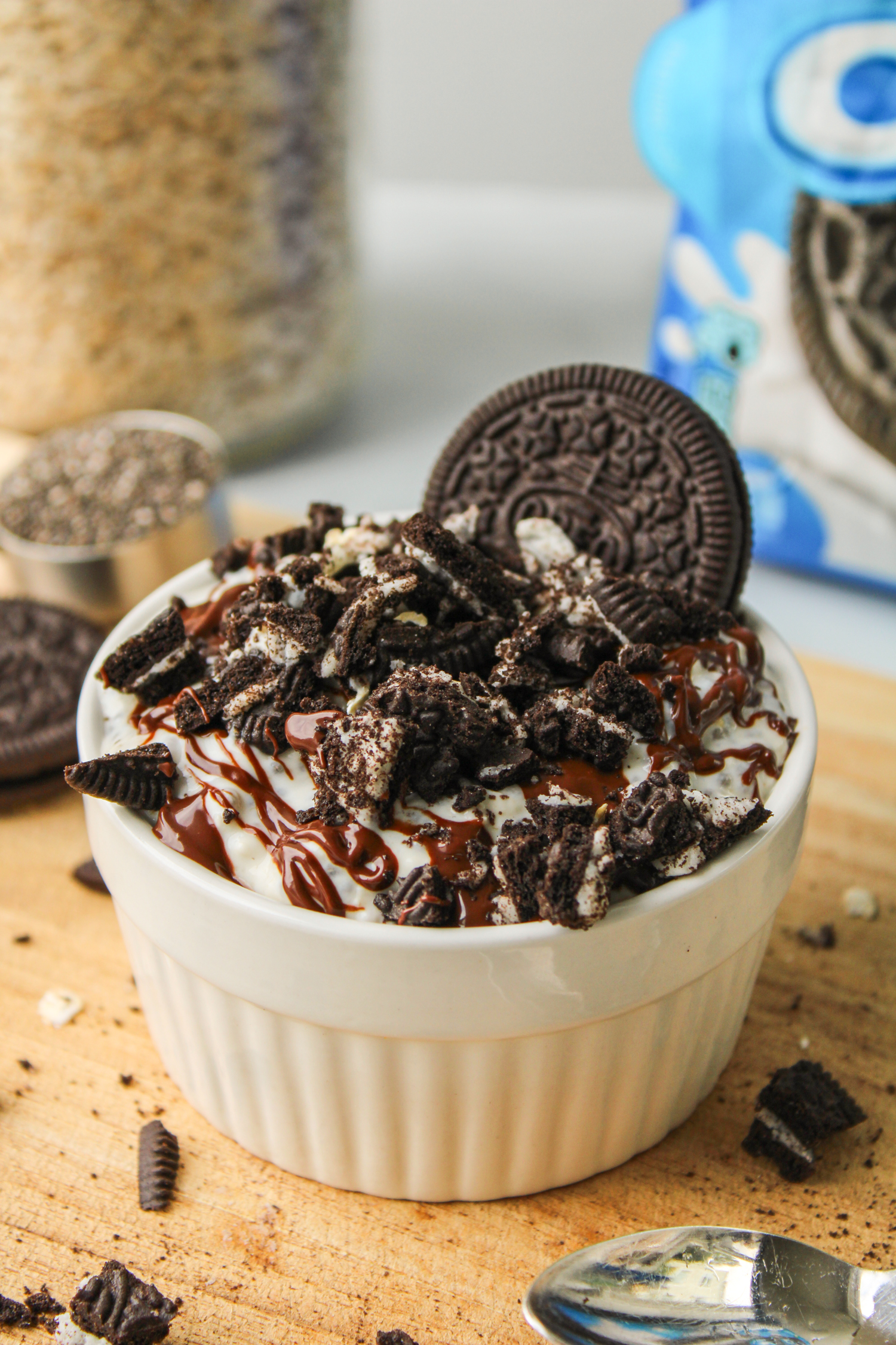 cookie overnight oats in a white ceramic dish topped with melted chocolate and cookie crumbs