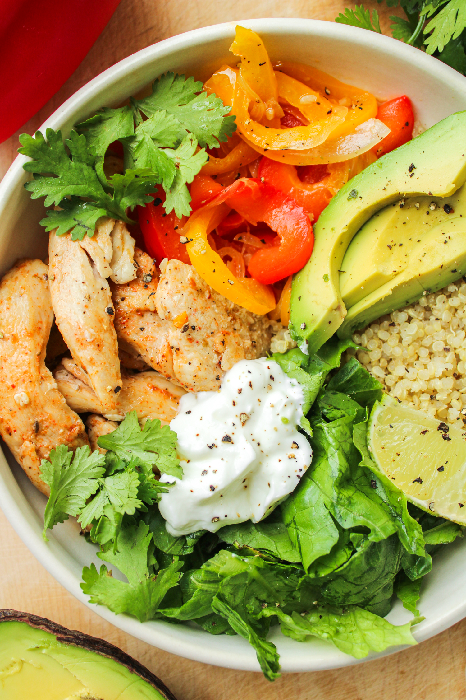 fajita chicken bowl in a white ceramic dish on a wooden cutting board