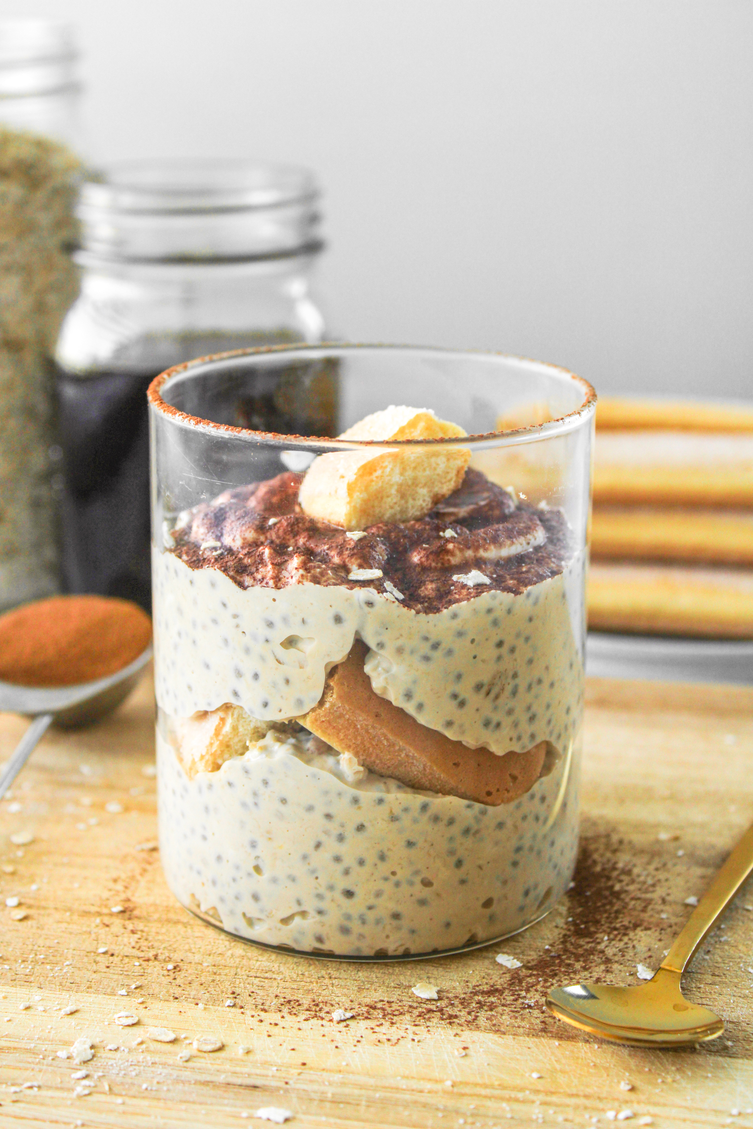 tiramisu overnight oats in glass jar on top of wooden board