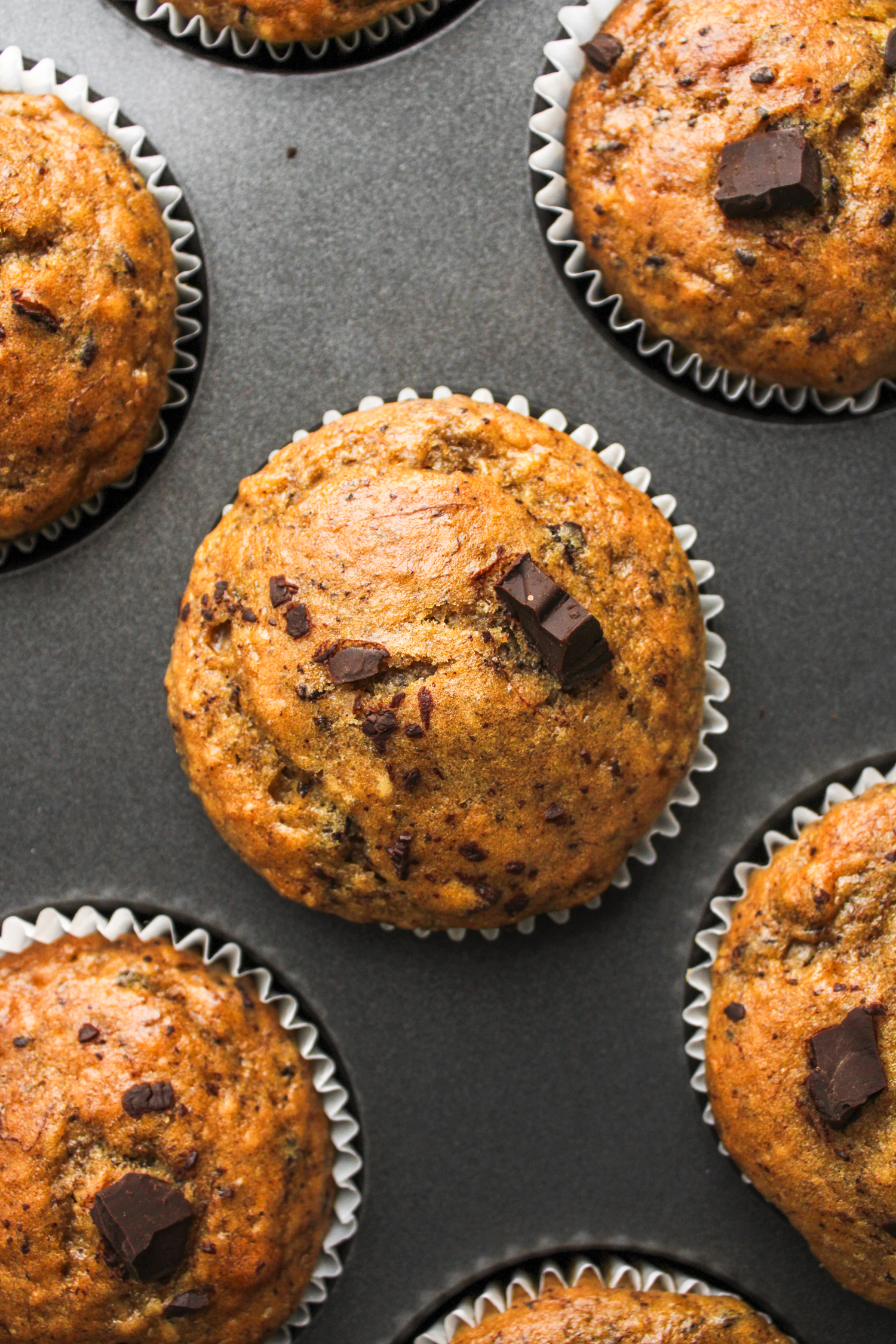 overhead shot of baked banana chocolate muffins in the muffin baking sheet