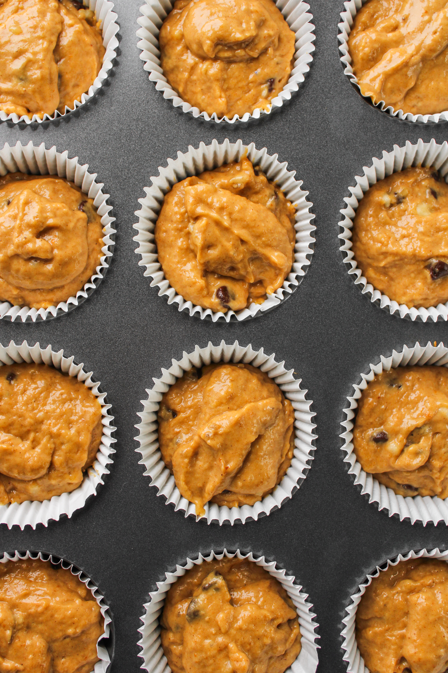 pumpkin banana chocolate chip muffin batter in muffin baking tray