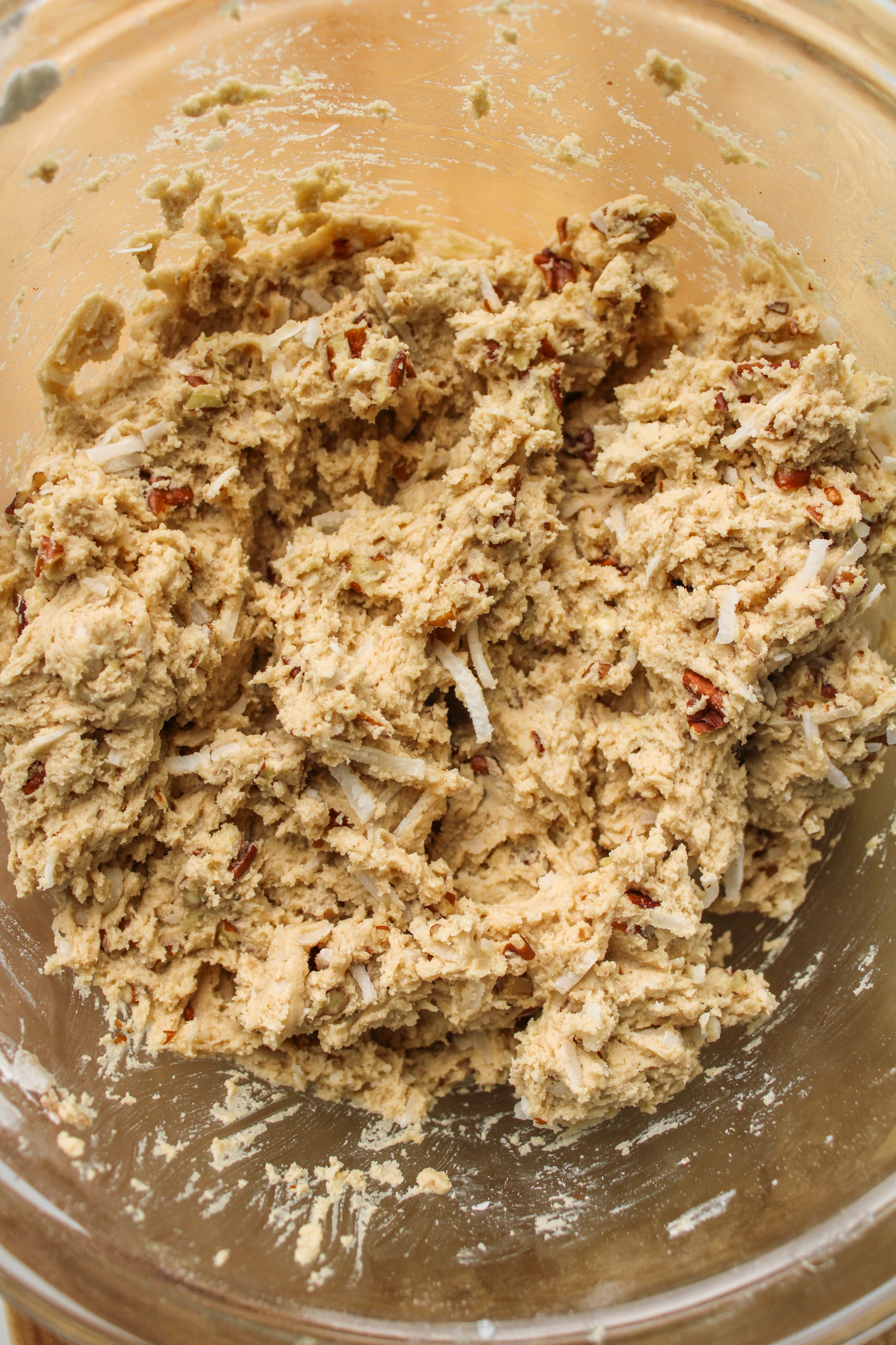 cookie dough with coconut and pecans in a glass bowl