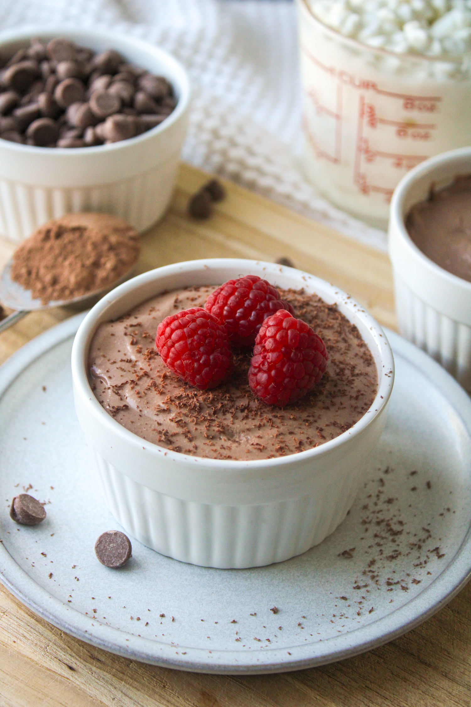 cottage cheese chocolate mousse in a white ceramic dish, topped with chocolate shavings and raspberries