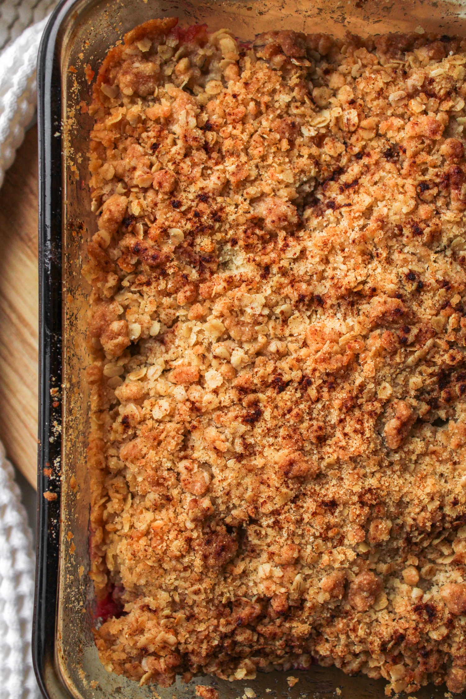 baking apple blackberry crumble in an 8x8" baking dish cooling on a wooden cutting board