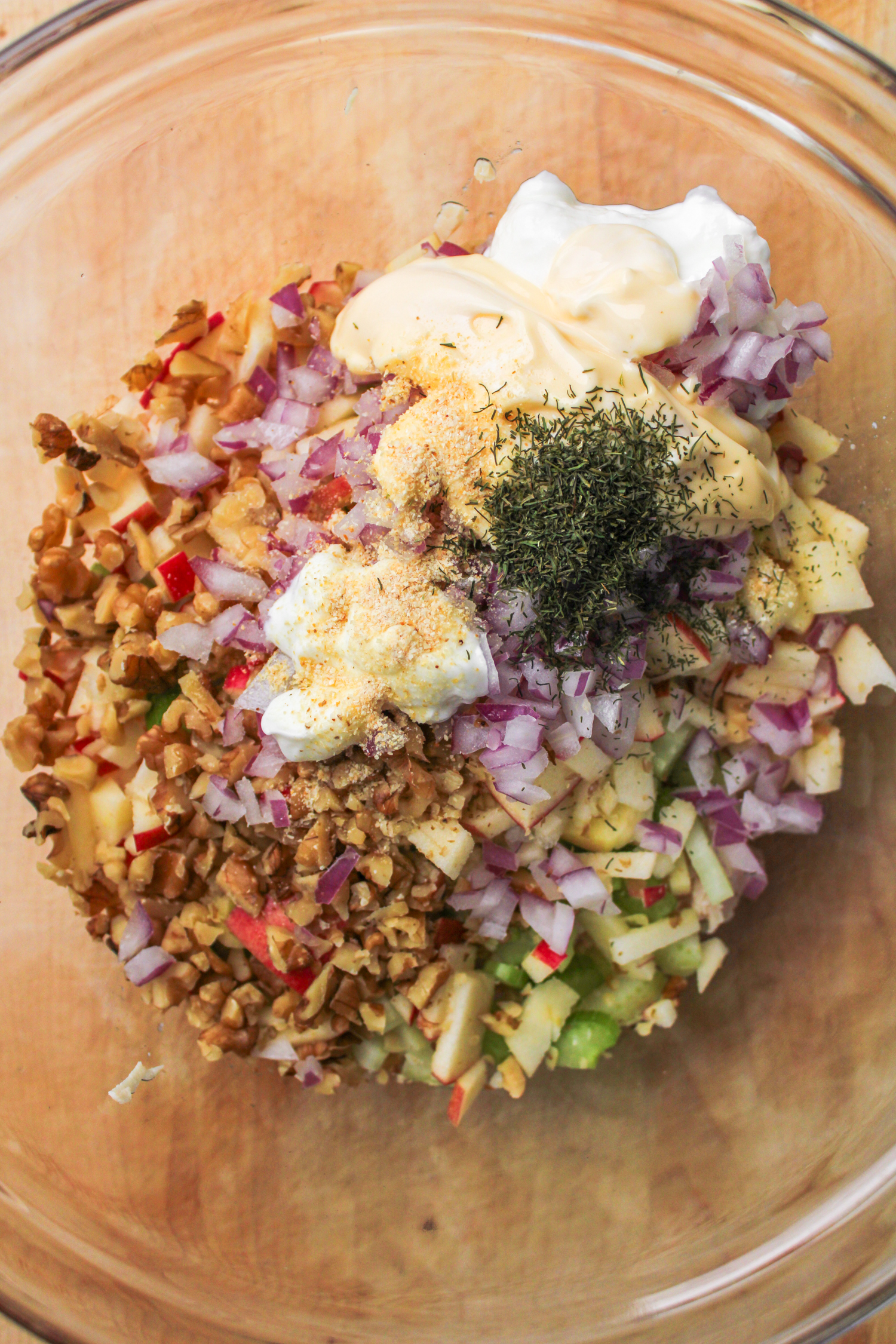 chicken salad ingredients in a large glass mixing bowl