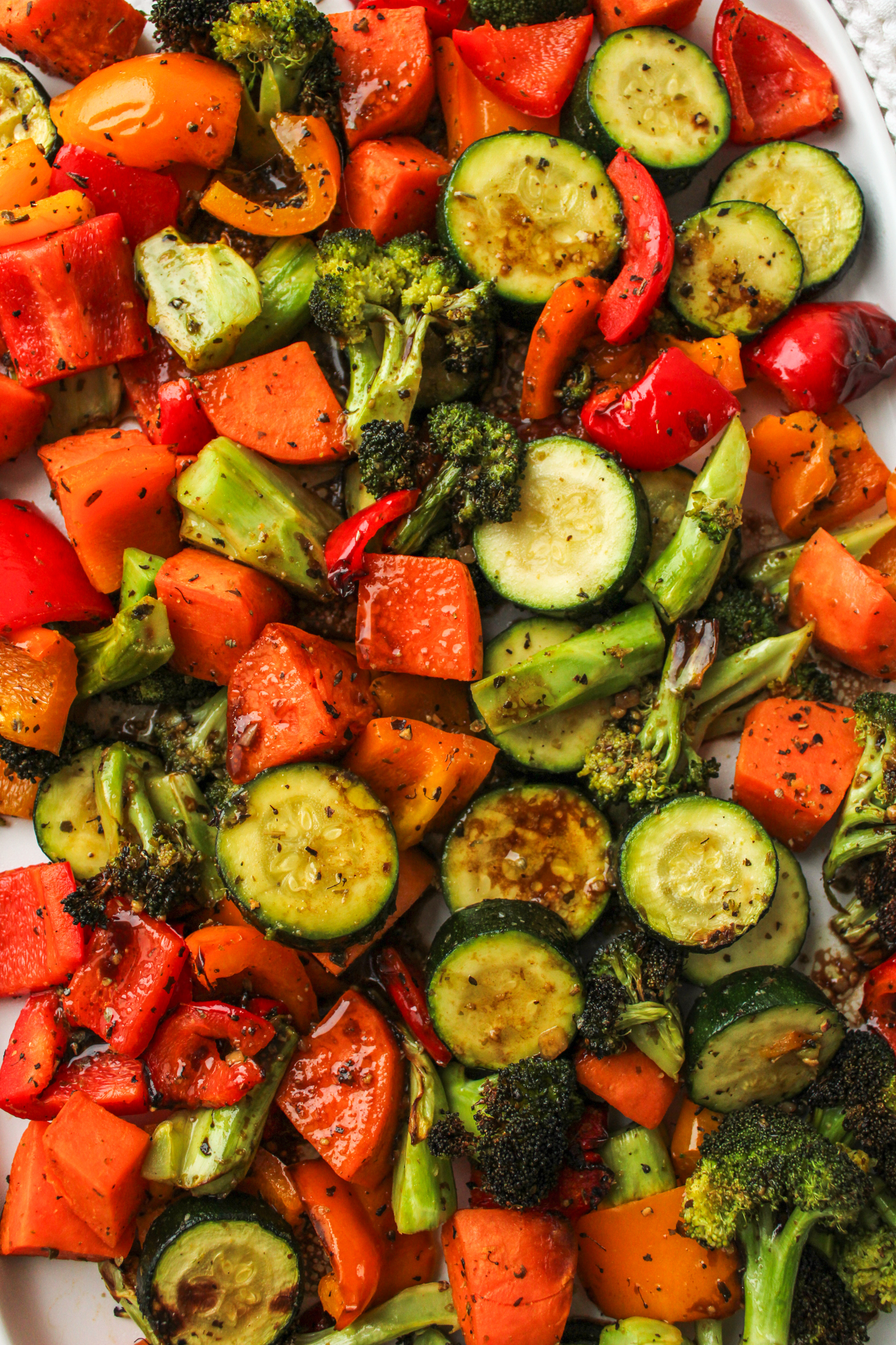 air fryer roasted vegetables with maple balsamic dressing on a large white ceramic serving plate