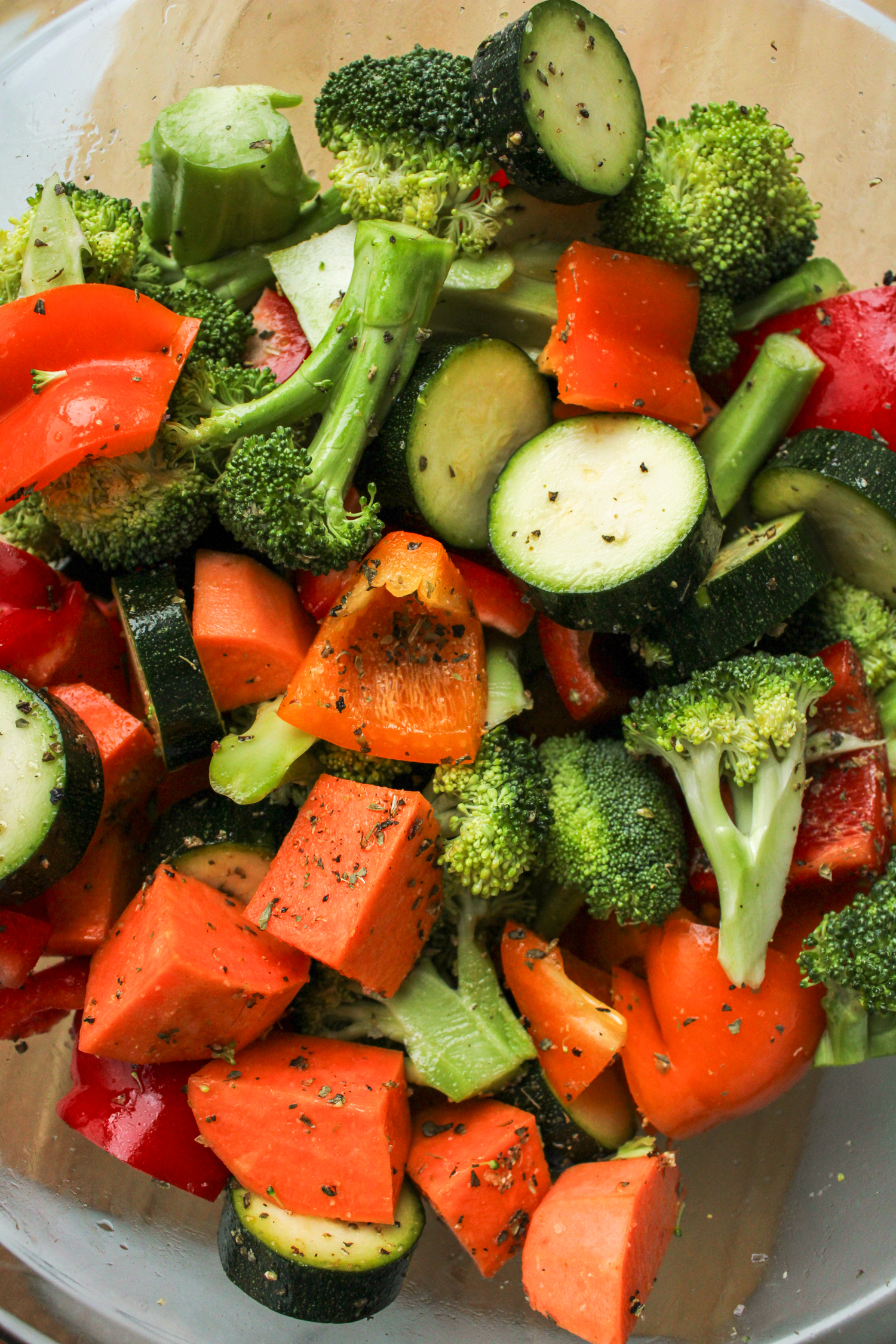 a variety of raw chopped winter vegetables in a large glass bowl