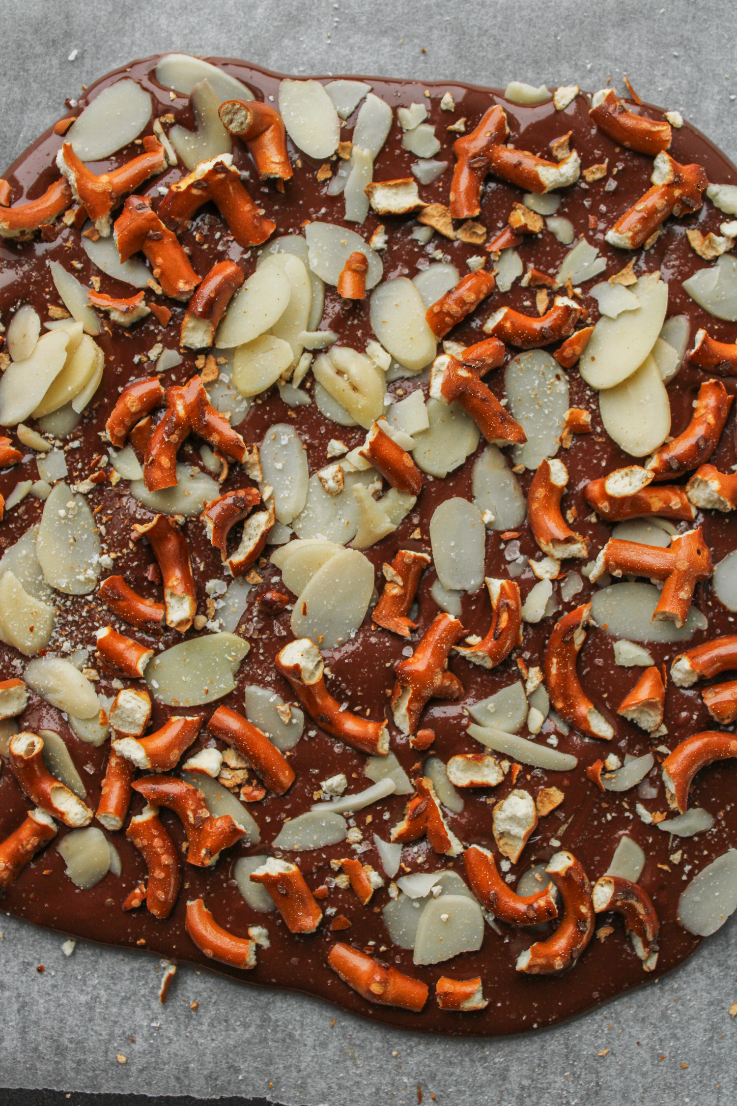 solid piece of chocolate almond bark on top of parchment paper, prior to being refrigerated 