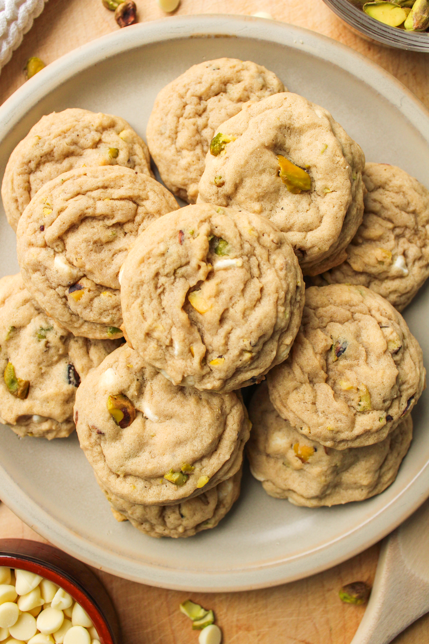 pistachio chocolate chip cookies layered on top of one another on a grey ceramic plate