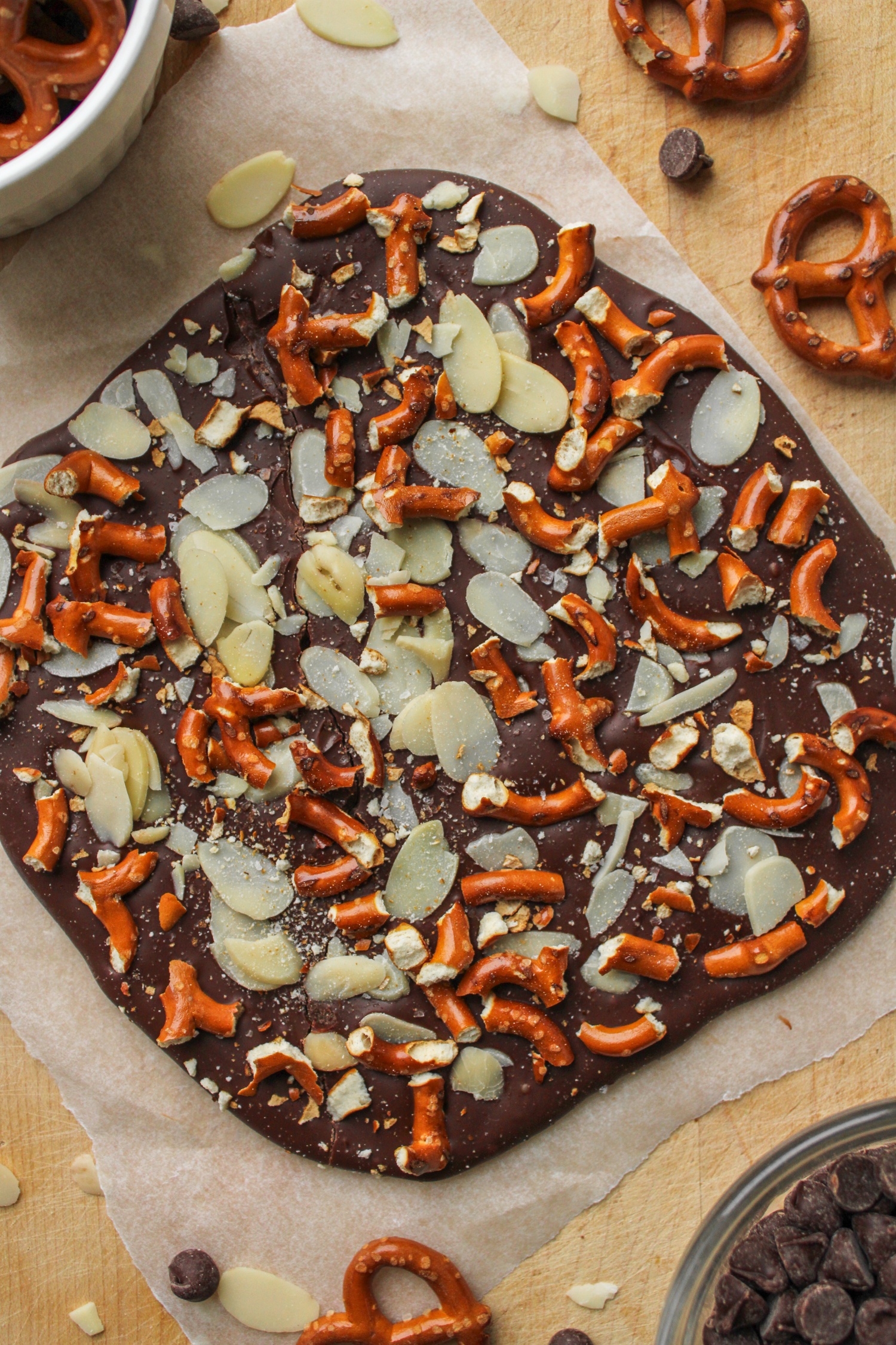 solid piece of chocolate almond bark on top of parchment paper on a wooden cutting board