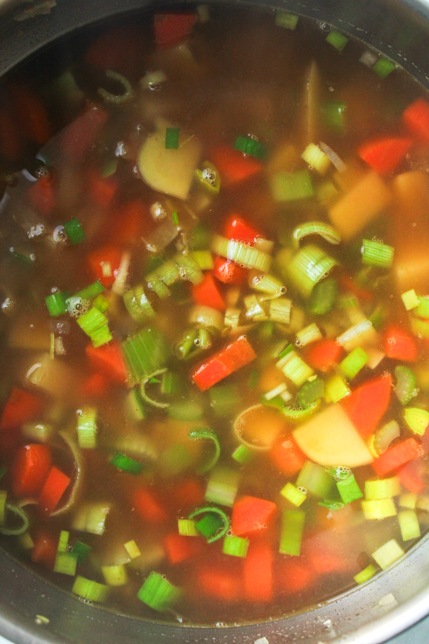 chicken broth with a variety of chopped veggies in a large pot