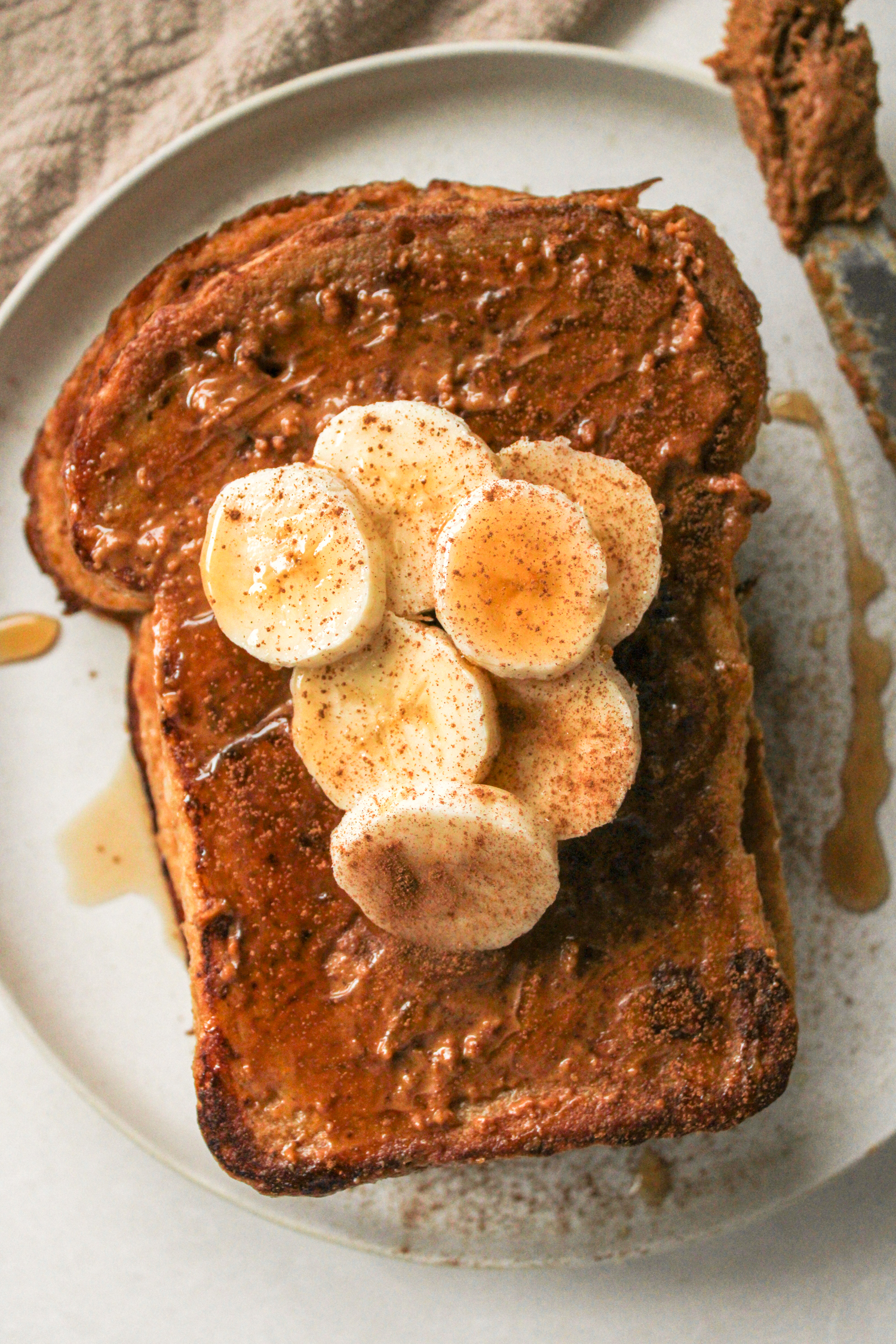 overhead shot of biscoff sourdough french toast topped with biscoff spread and sliced bananas