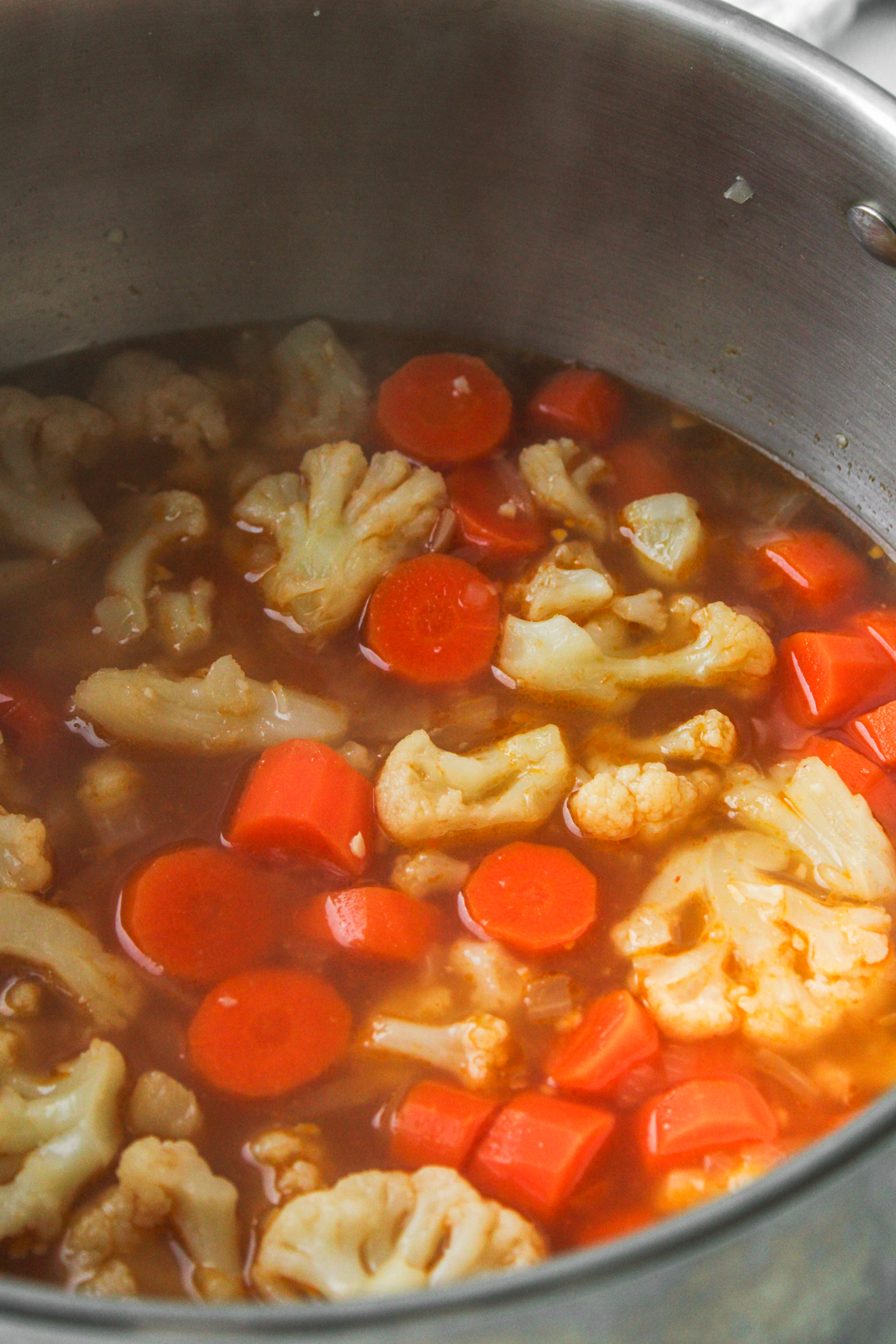 carrots, cauliflower and vegetable stock cooking in a large pot