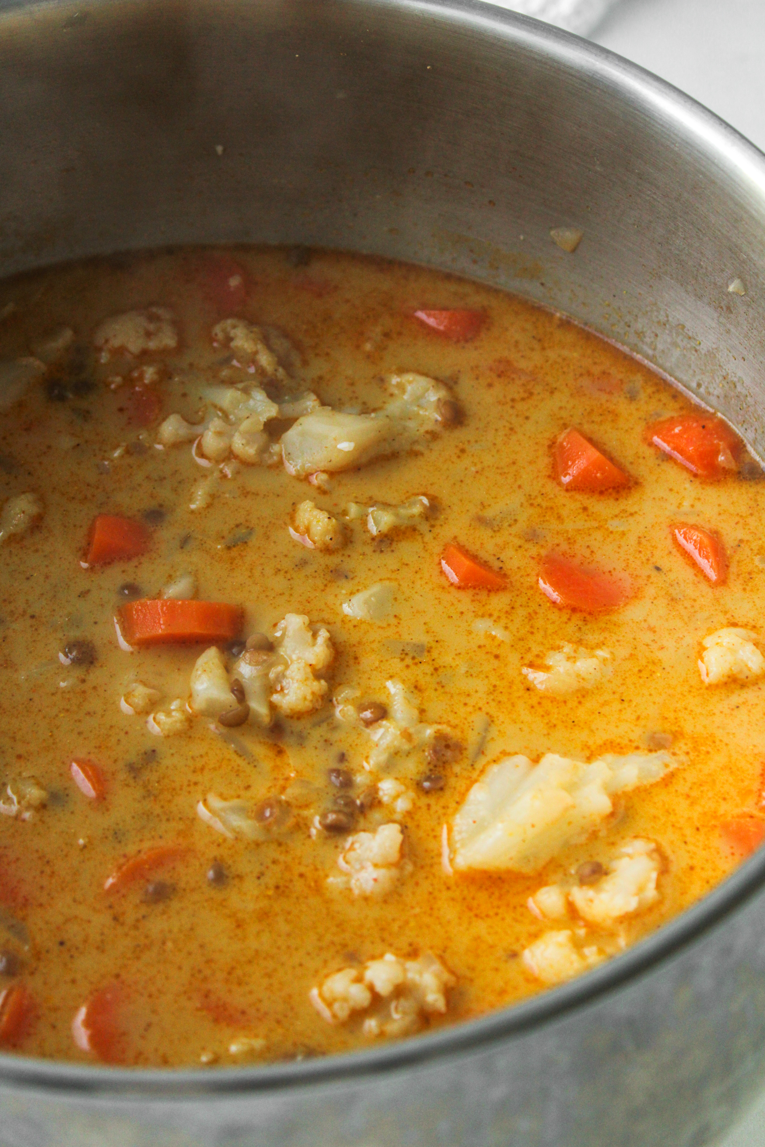 ingredients for carrot soup cooking in a large pot