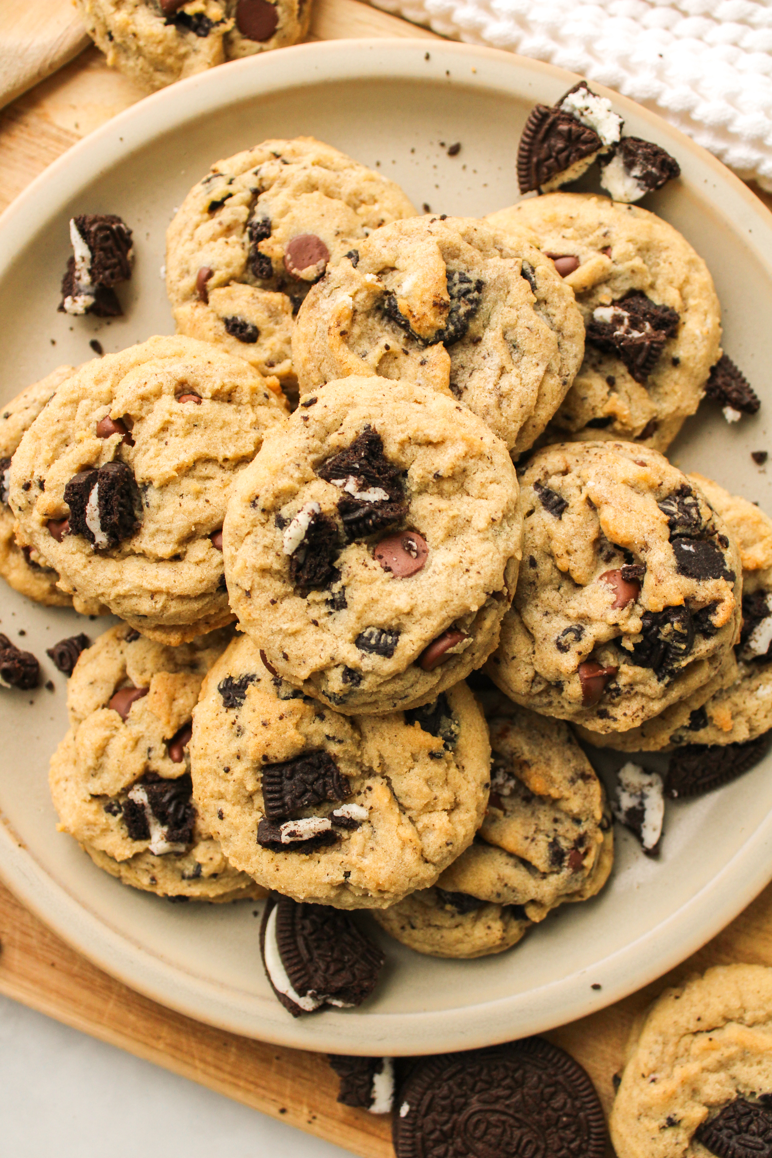 oreo and chocolate chips cookies piled on top of each other on a ceramic plate