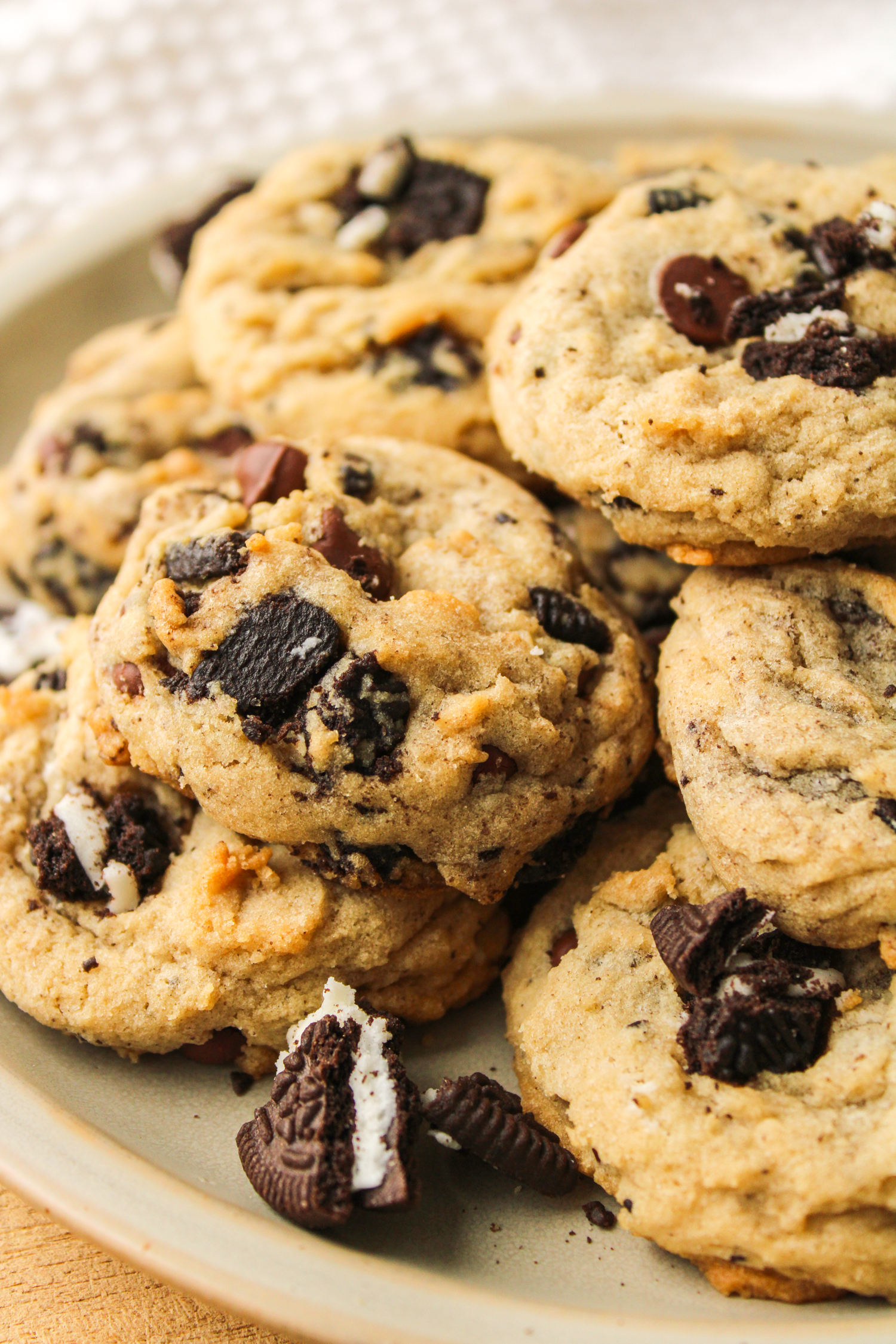 profile shot of oreo and chocolate chips cookies piled on top of each other on a ceramic plate