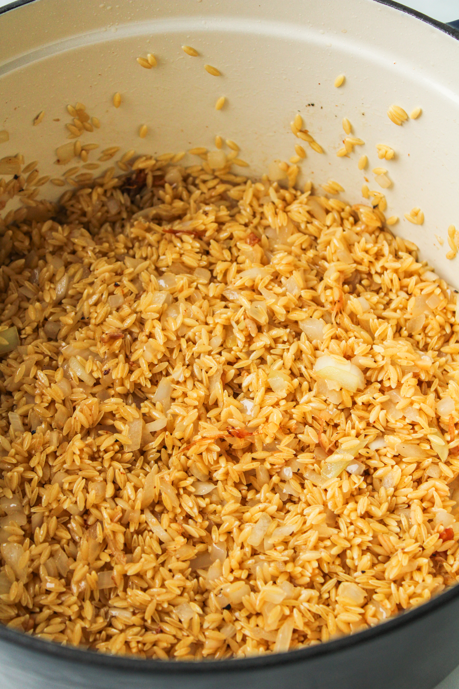 uncooked orzo in a large ceramic pot