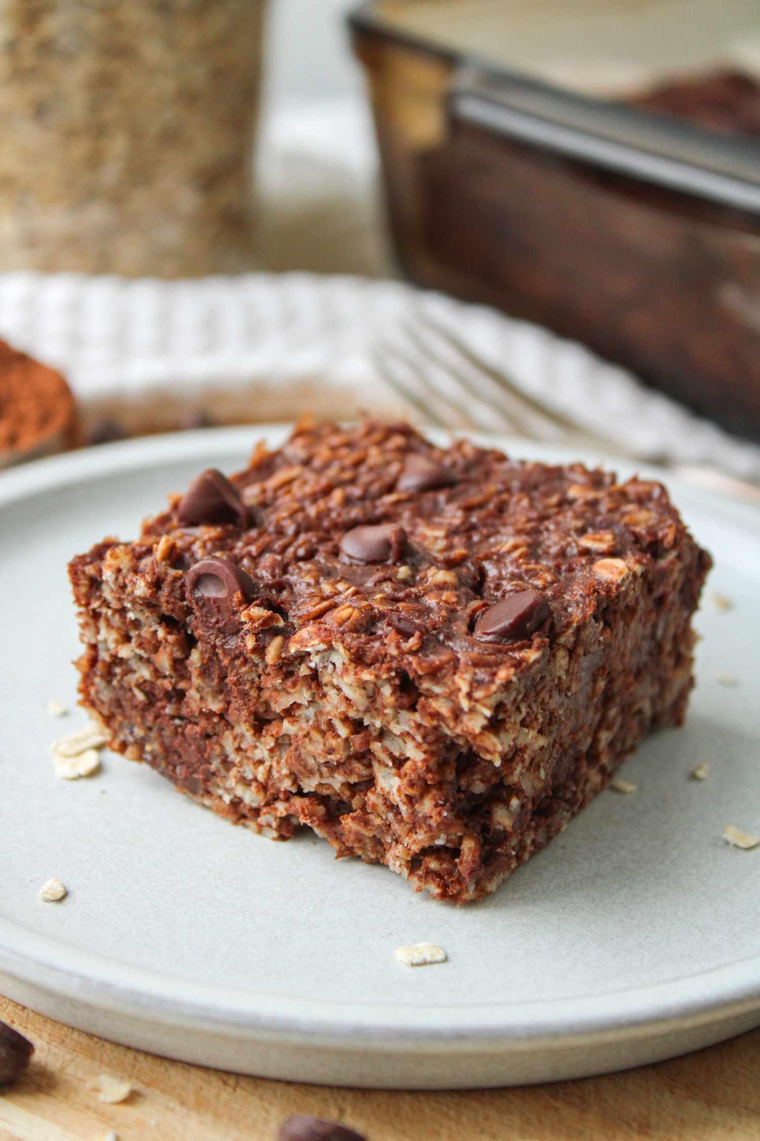 A square of double chocolate baked oatmeal on top of a white ceramic plate