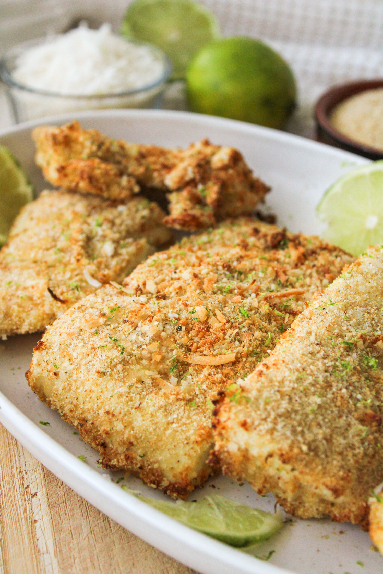 side angle of overhead shot of coconut lime air fryer halibut fillets on a large white ceramic plate