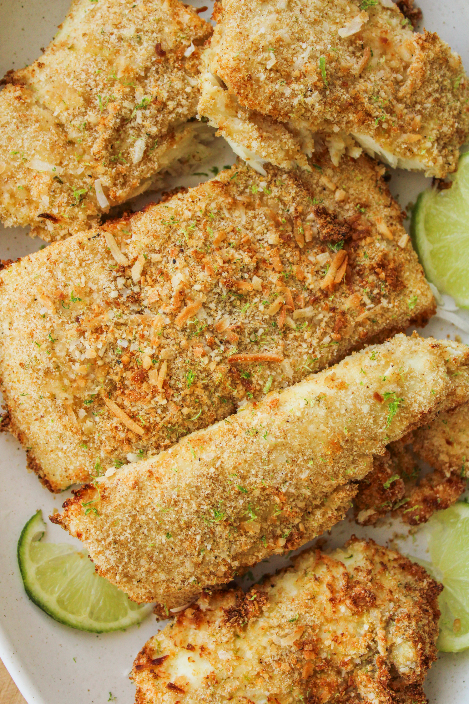 overhead shot of coconut lime air fryer halibut fillets on a large white ceramic plate