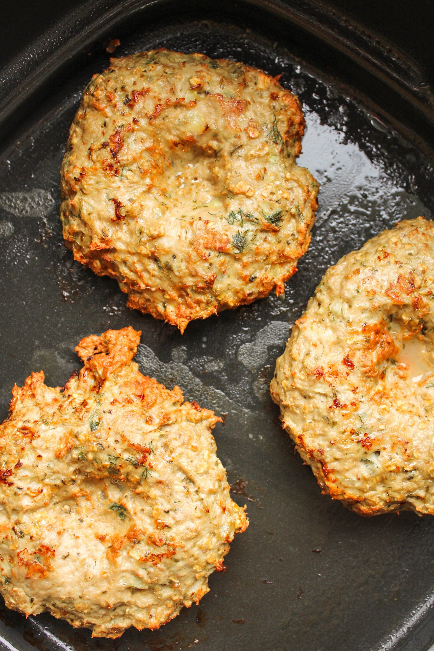 cooked hamburger patties in the air fryer basket