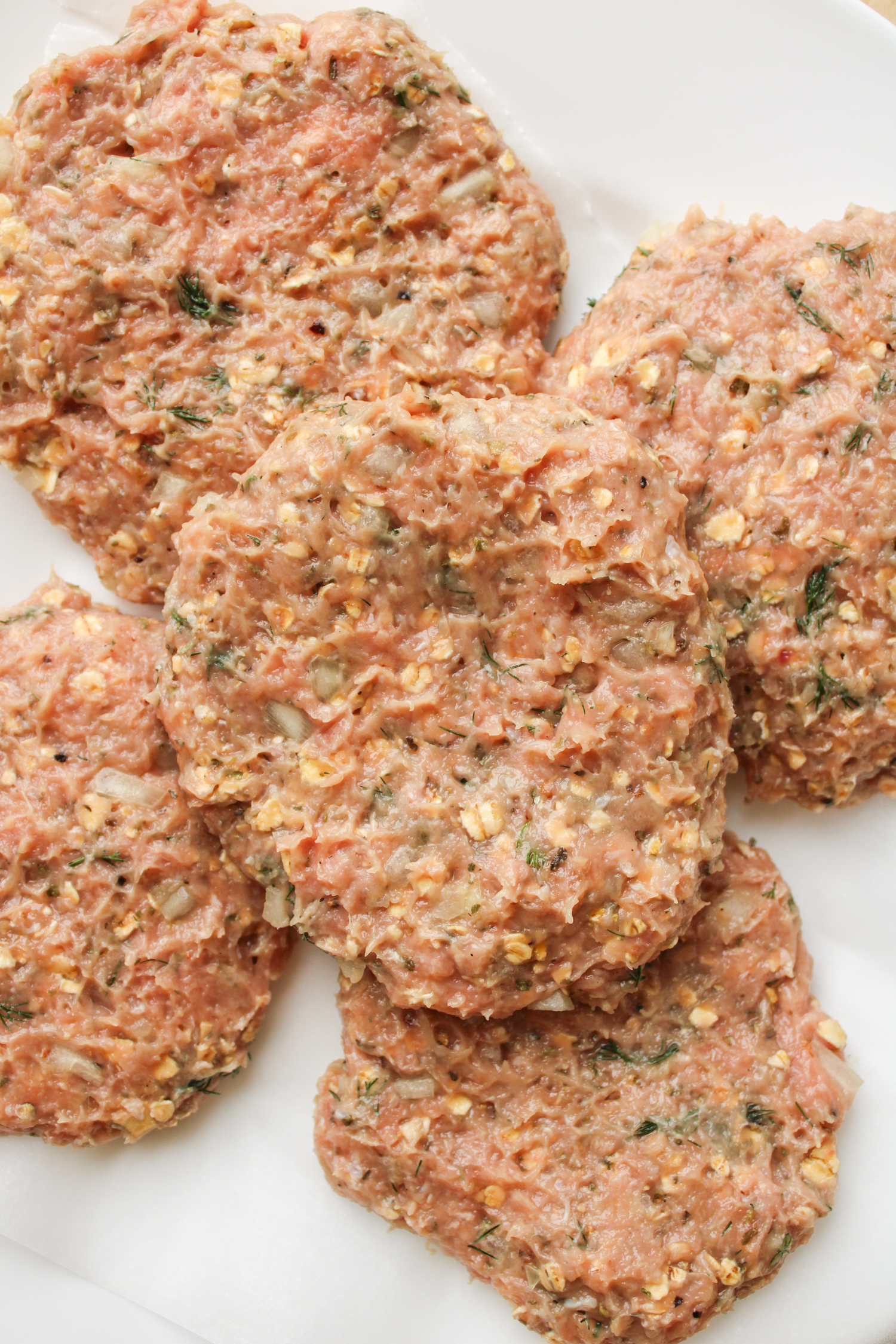 raw hamburger patties on top of parchment paper
